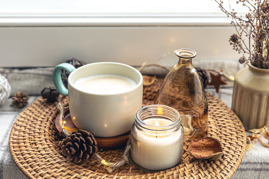 a cup of decaf tea and a relaxing candle with autumnal home decor